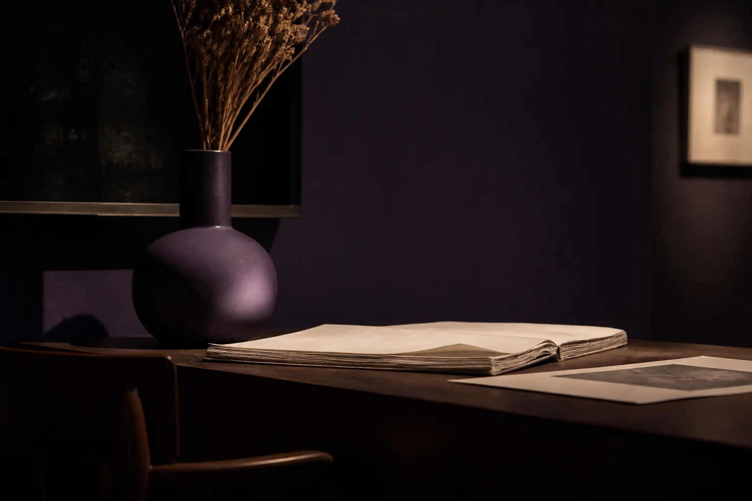 Escritorio de estudio con papel color marfil y jarrón violeta bajo luz cálida